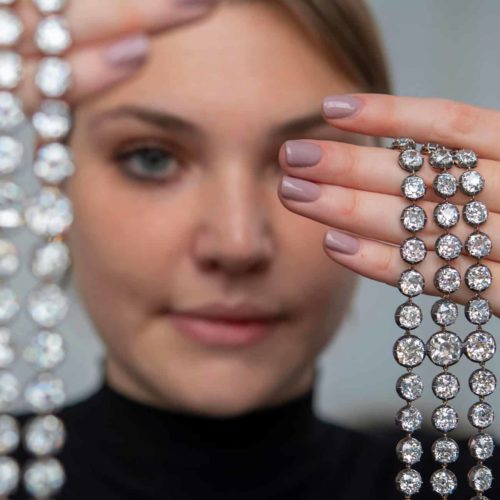 Foto impiegata di Christie's che tiene nelle mani i braccialetti di diamanti di Maria Antonietta in asta a novembre 2021